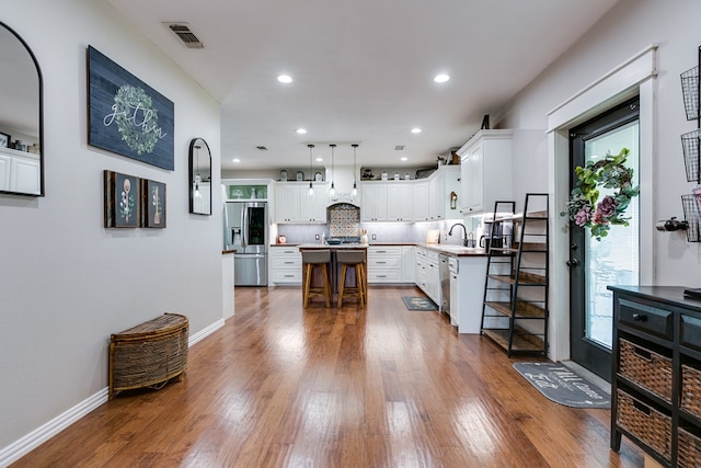 kitchen with a kitchen island, appliances with stainless steel finishes, dark wood finished floors, and backsplash