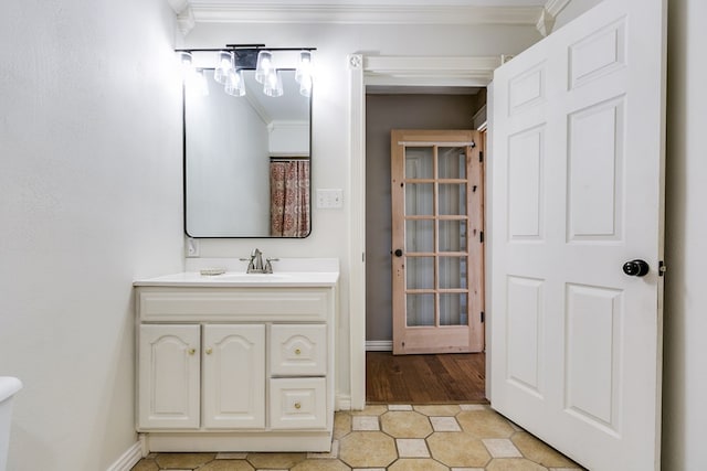 bathroom featuring ornamental molding, tile patterned flooring, vanity, and baseboards