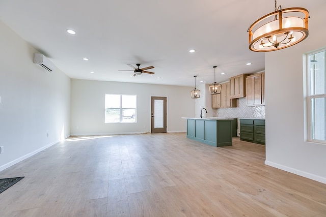 kitchen with tasteful backsplash, open floor plan, light wood-type flooring, a wall mounted air conditioner, and baseboards