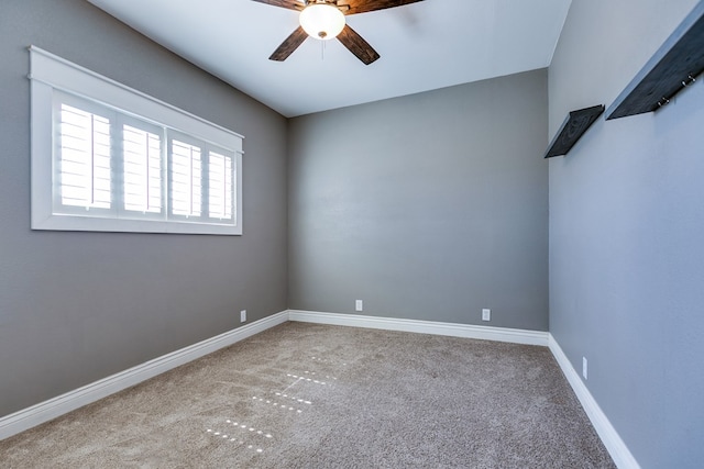 carpeted empty room featuring ceiling fan and baseboards