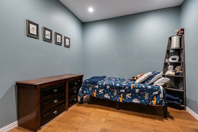 bedroom featuring light wood finished floors and baseboards