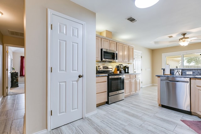 kitchen with appliances with stainless steel finishes, light brown cabinetry, visible vents, and tasteful backsplash