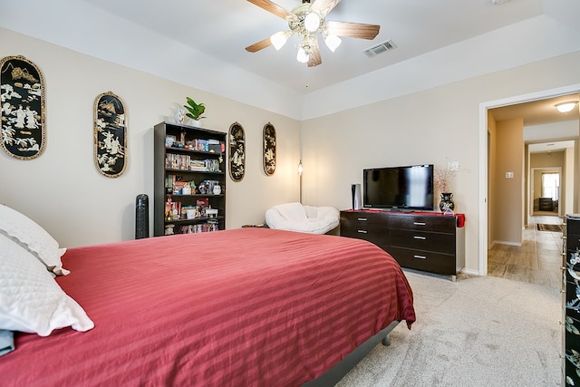 bedroom with baseboards, visible vents, a ceiling fan, and light colored carpet