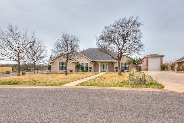 view of front of home featuring a garage, driveway, brick siding, and a front lawn