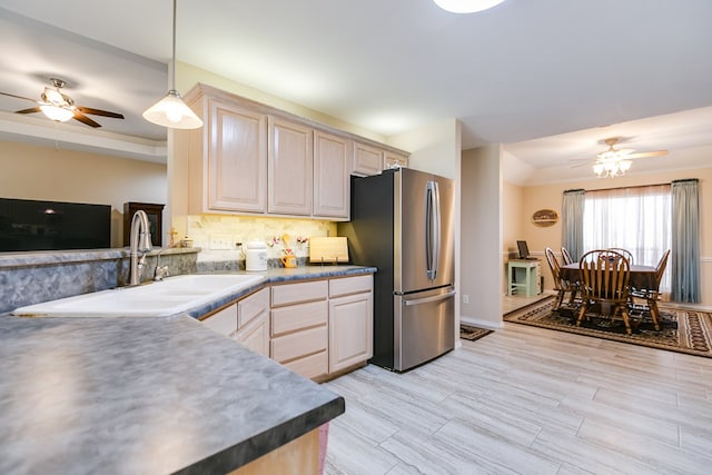 kitchen with tasteful backsplash, freestanding refrigerator, a sink, and a ceiling fan