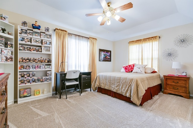 bedroom featuring carpet flooring, a raised ceiling, and a ceiling fan