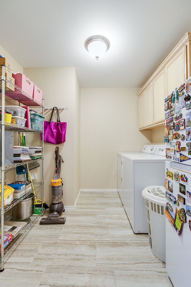 laundry area with separate washer and dryer, cabinet space, and baseboards