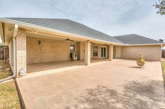 back of house featuring ceiling fan, a patio, brick siding, and roof with shingles