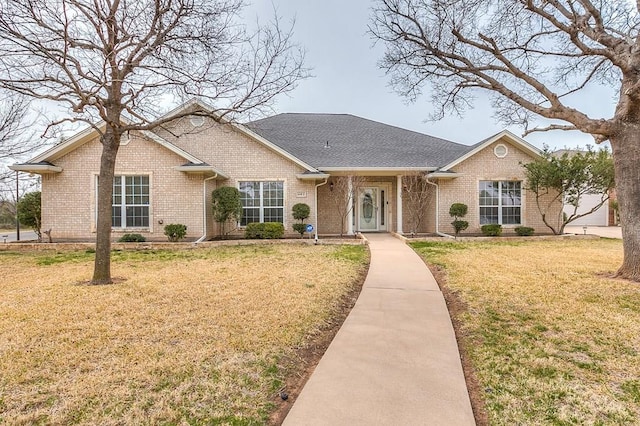 601 Burlington Rd, San Angelo, TX 76901 - view of front of house featuring brick siding, a front yard, and roof with shingles