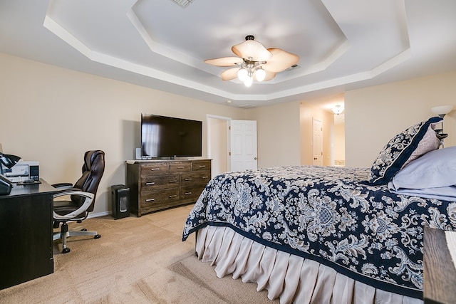 carpeted bedroom featuring ceiling fan, a tray ceiling, and baseboards