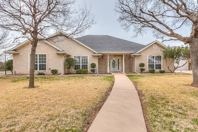 single story home with a shingled roof, brick siding, and a front lawn