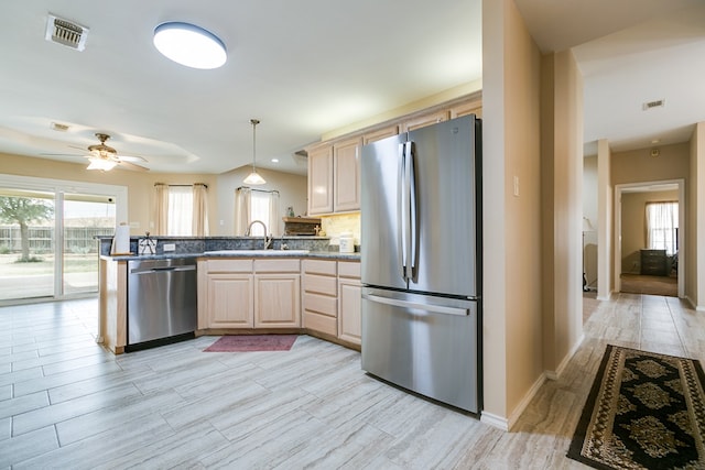 kitchen featuring a peninsula, visible vents, stainless steel appliances, and a sink