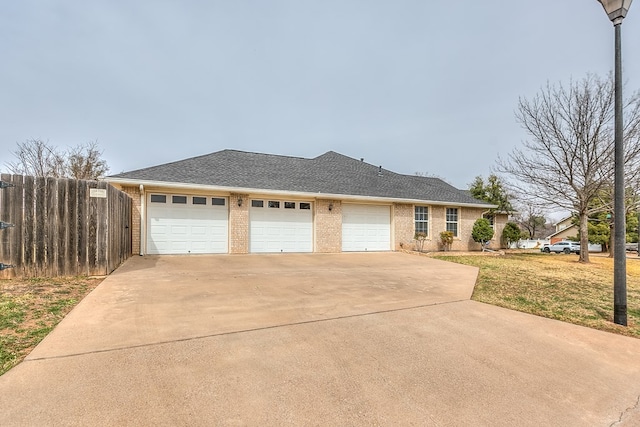 ranch-style house featuring a garage, a shingled roof, concrete driveway, fence, and brick siding