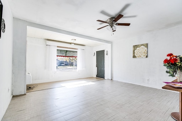 empty room with ceiling fan and light hardwood / wood-style flooring