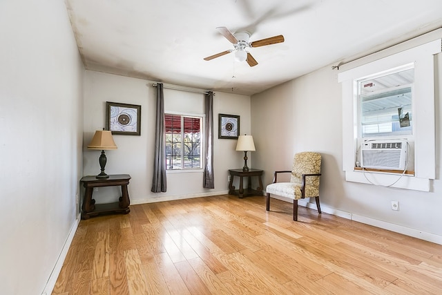 living area with cooling unit, ceiling fan, and light hardwood / wood-style flooring