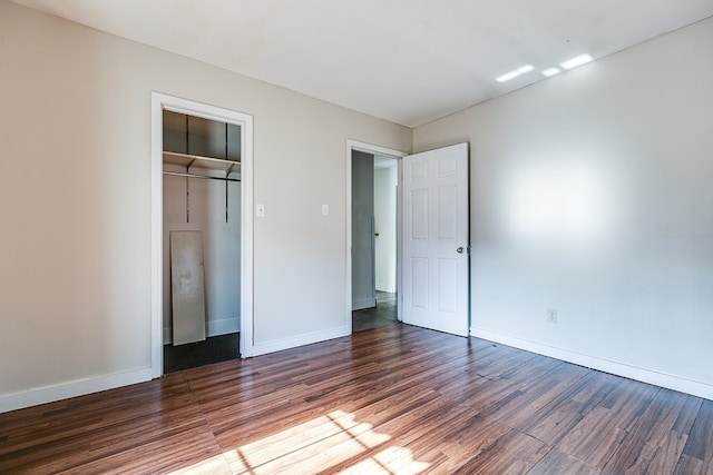 unfurnished bedroom featuring dark hardwood / wood-style floors and a closet