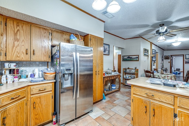 kitchen with crown molding, a textured ceiling, stainless steel fridge, ceiling fan, and decorative backsplash