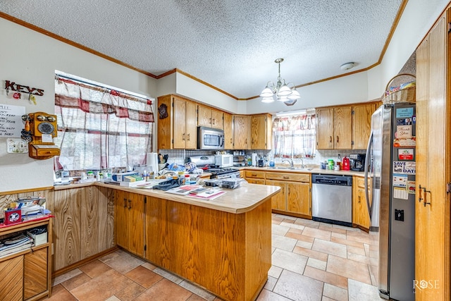 kitchen with appliances with stainless steel finishes, tasteful backsplash, sink, a notable chandelier, and kitchen peninsula