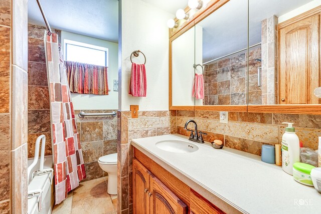 bathroom with tile walls, vanity, toilet, and a shower with shower curtain