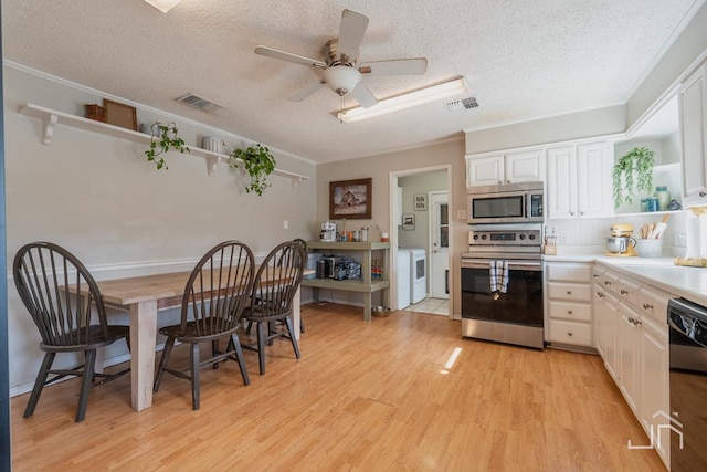 kitchen featuring visible vents, appliances with stainless steel finishes, light wood-style floors, and separate washer and dryer