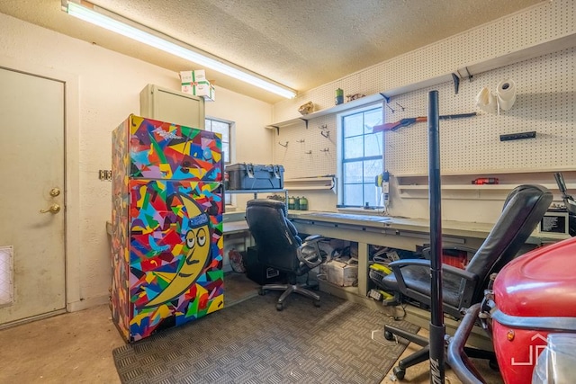 office area featuring a workshop area, concrete floors, and a textured ceiling