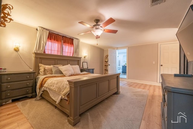 bedroom with light wood-type flooring, visible vents, ornamental molding, and a ceiling fan