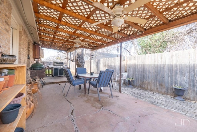 view of patio / terrace with a grill, outdoor dining space, and fence