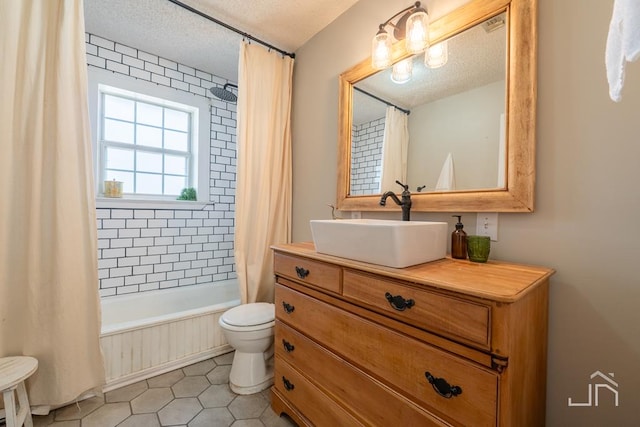 bathroom featuring toilet, a textured ceiling, shower / tub combo, tile patterned flooring, and vanity