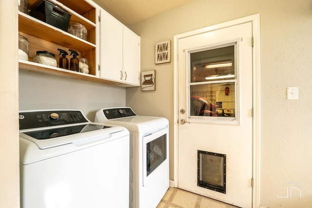 clothes washing area featuring washer and clothes dryer and cabinet space