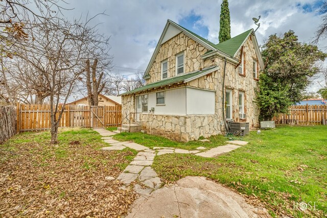 rear view of house featuring a yard