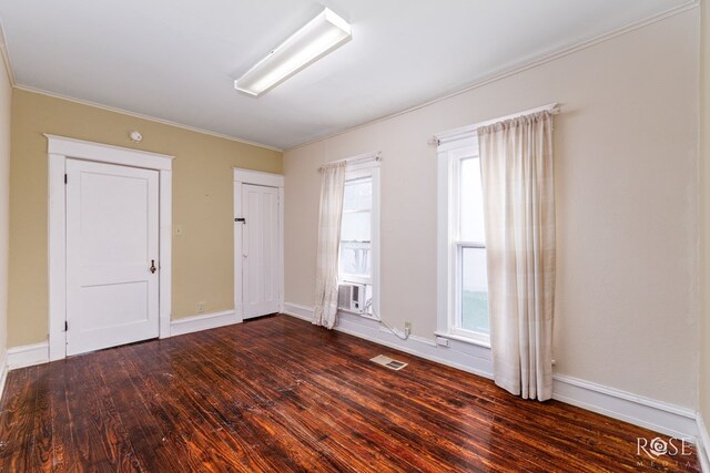 unfurnished room featuring crown molding, dark hardwood / wood-style flooring, and cooling unit