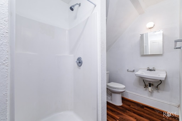 bathroom featuring hardwood / wood-style floors, toilet, sink, and a shower