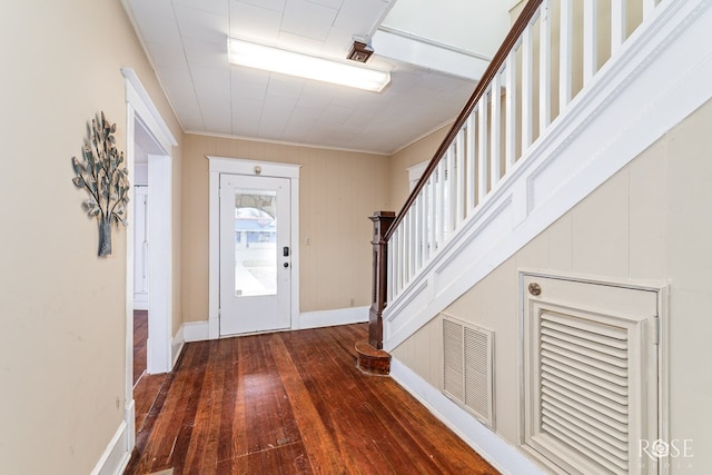 foyer entrance with ornamental molding and dark hardwood / wood-style floors