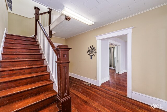 stairway featuring wood-type flooring and ornamental molding