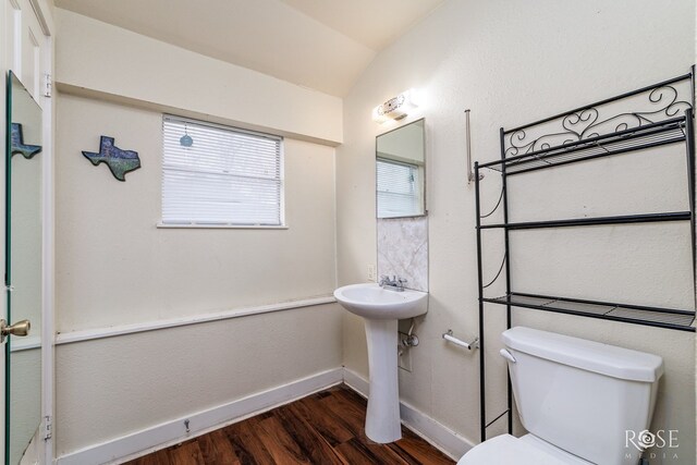 bathroom with lofted ceiling, sink, wood-type flooring, and toilet