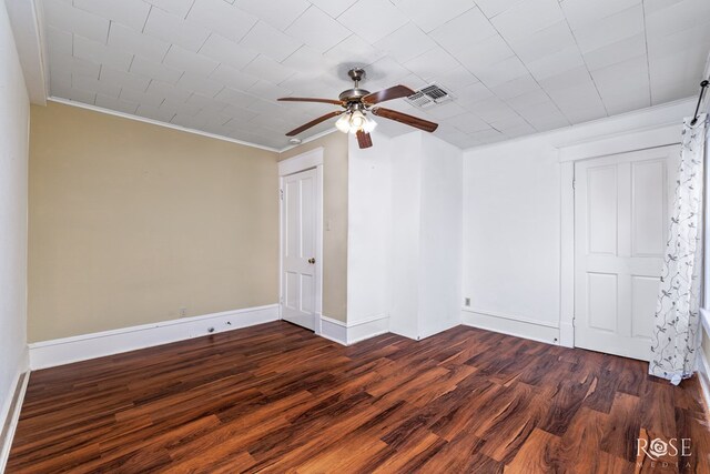 empty room featuring ceiling fan, ornamental molding, and dark hardwood / wood-style flooring