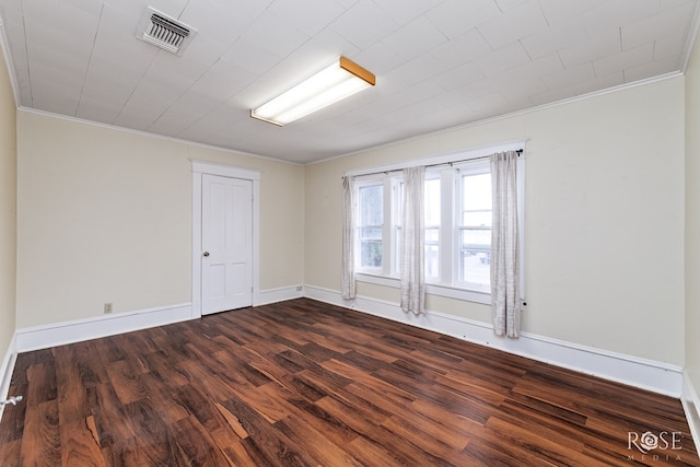 spare room with dark hardwood / wood-style flooring and crown molding