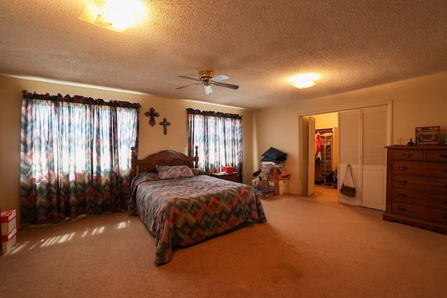 carpeted bedroom featuring a textured ceiling, ceiling fan, and a closet