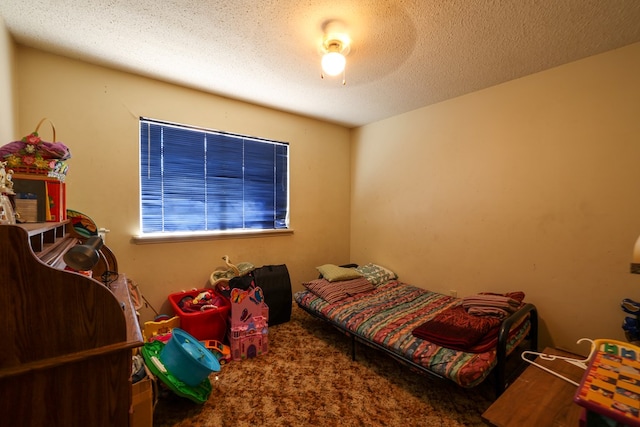 carpeted bedroom with a textured ceiling and ceiling fan