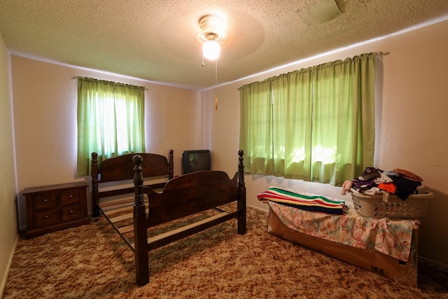 bedroom with carpet, a textured ceiling, and ceiling fan