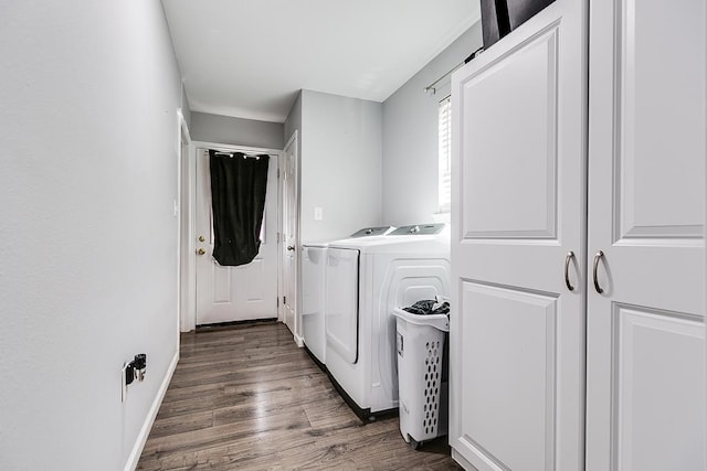 laundry room with laundry area, baseboards, separate washer and dryer, and wood finished floors