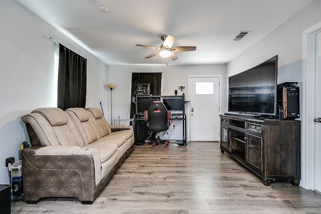 living room with ceiling fan, visible vents, and wood finished floors