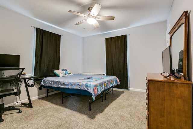 bedroom with baseboards, a ceiling fan, and light colored carpet