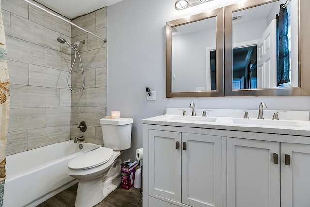 bathroom featuring double vanity, wood finished floors, a sink, and toilet