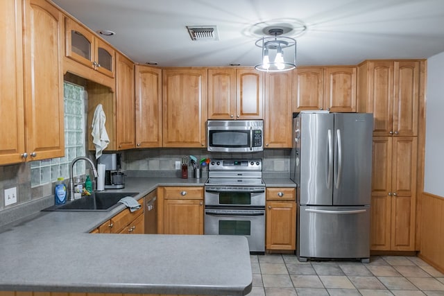 kitchen featuring a sink, appliances with stainless steel finishes, backsplash, and visible vents