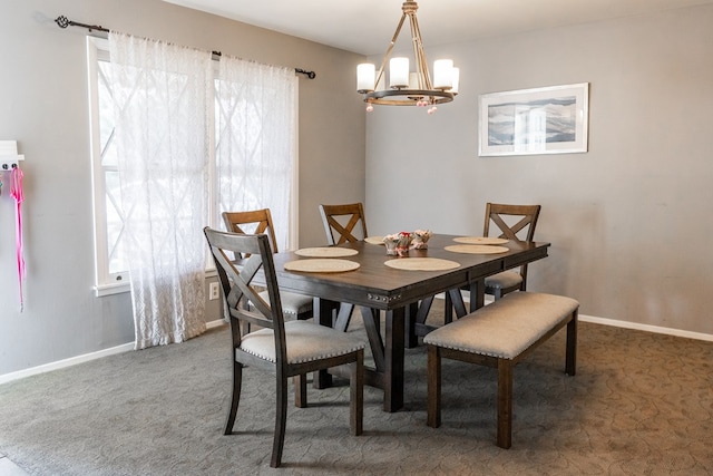 dining space featuring carpet flooring, baseboards, and a chandelier