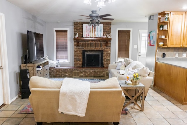 living room with a ceiling fan, a brick fireplace, and light tile patterned floors