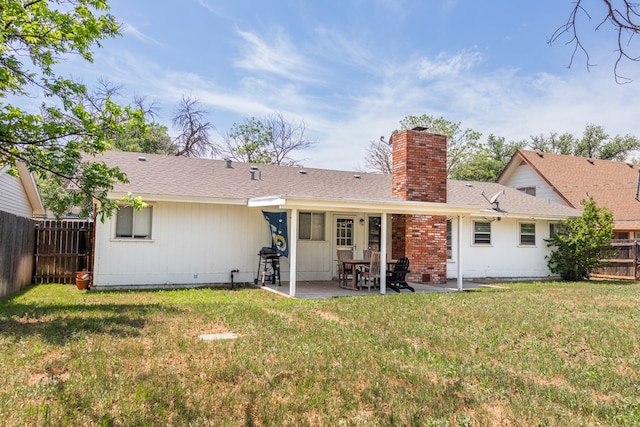 rear view of property featuring a fenced backyard, a patio, a chimney, and a lawn