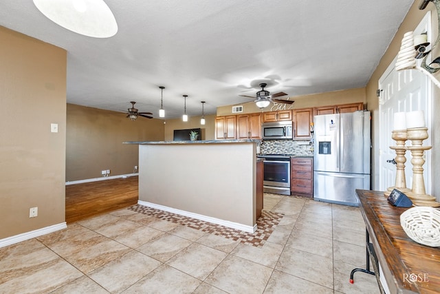 kitchen featuring pendant lighting, ceiling fan, tasteful backsplash, light tile patterned flooring, and stainless steel appliances