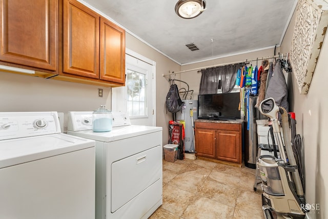 clothes washing area featuring water heater, crown molding, visible vents, independent washer and dryer, and cabinet space